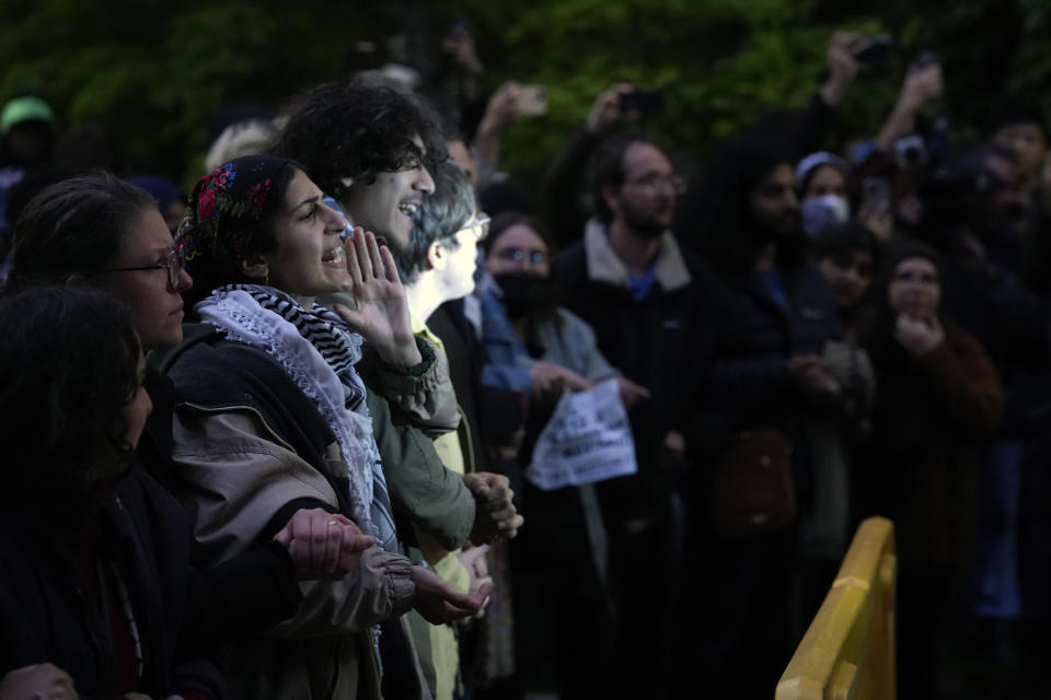 Pro-Palestinian protesters chat as police kept them away from the university's quad while the student encampment is dismantled at the University of Chicago, Tuesday, May 7, 2024. (AP Photo/Charles Rex Arbogast)
