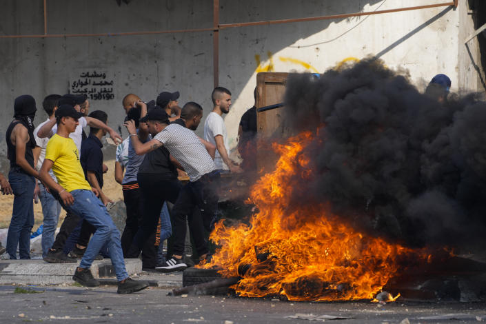 Palestinian demonstrators clash with the Israeli army while forces carry out an operation in the West Bank town of Nablus, Tuesday, Aug. 9, 2022. Israeli police said forces encircled the home of Ibrahim al-Nabulsi, who they say was wanted for a string of shootings in the West Bank earlier this year. They said al-Nabulsi and another Palestinian militant were killed in a shootout at the scene, and that troops found arms and explosives in his home. (AP Photo/Majdi Mohammed)
