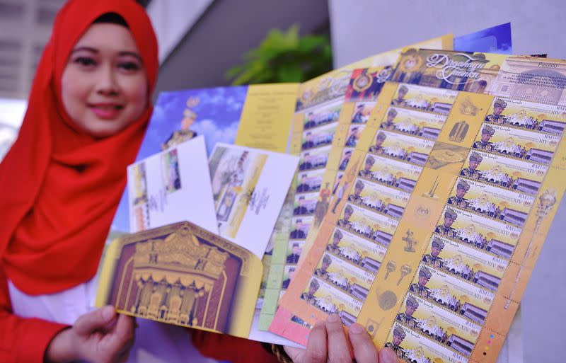 Pos Malaysia Berhad officer, Norsazila Zainuddin showing the special stamps of the Yang di-Pertuan Agong after a pre-launch press conference at Pos Malaysia headquarters, Kuala Lumpur, December 6, 2016. — Bernama pic