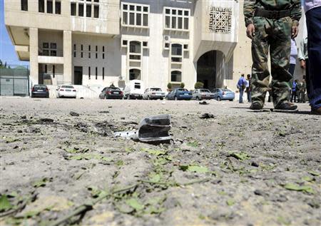 A mortar shell is seen in front of vehicles after mortar bombs landed on two areas in Damascus April 29, 2014, in this handout photograph released by Syria's national news agency SANA. REUTERS/SANA/Handout via Reuters