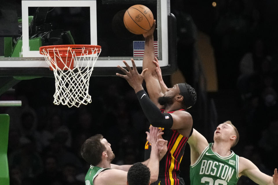 Atlanta Hawks forward Bruno Fernando (24) lines up a dunk while defended by Boston Celtics forward Sam Hauser, right, and center Luke Kornet, left, during the first half of an NBA basketball game Wednesday, Feb. 7, 2024, in Boston. (AP Photo/Charles Krupa)
