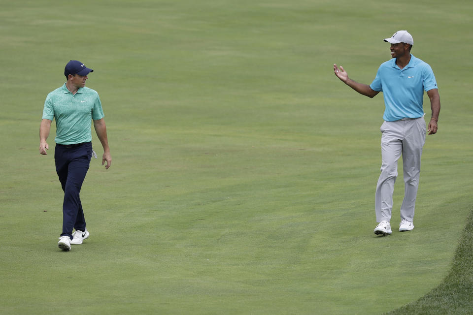 Tiger Woods, right, smiles as he talks to Rory McIlroy, of Northern Ireland, while walking on the sixth fairway during the first round of the Memorial golf tournament, Thursday, July 16, 2020, in Dublin, Ohio. (AP Photo/Darron Cummings)