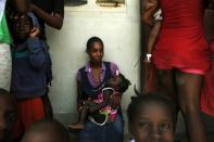 Haitian mother Beltha Desir, 30, holds her child at a school in Fond Parisien on July 3, 2015