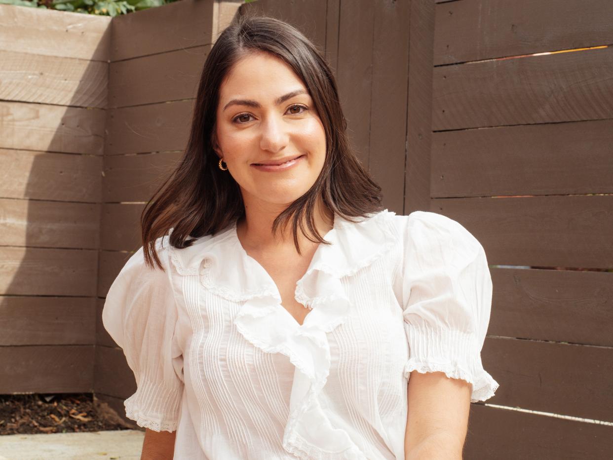 Sarah Levy, author, sitting in sun with white blouse, higher resolution