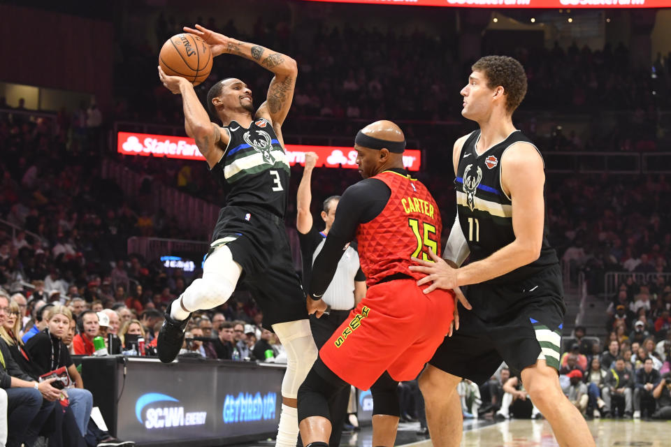 Milwaukee Bucks guard George Hill (3) tries to shoot as center Brook Lopez (11) sets a pick on Atlanta Hawks guard Vince Carter during the first half of an NBA basketball game Friday, Dec. 27, 2019, in Atlanta. (AP Photo/John Amis)