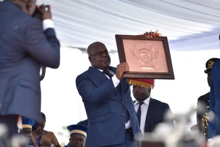 Felix Tshisekedi holds the country's coat of arms during the inauguration ceremony