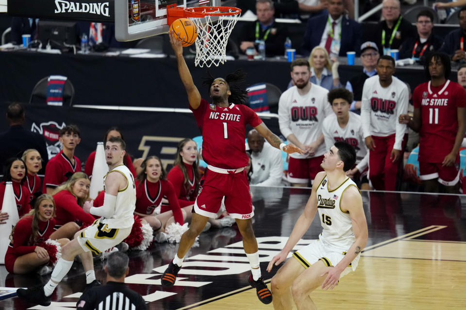 NC State guard Jayden Taylor (1) shoots as Purdue center Zach Edey defends during the second half of the NCAA college basketball game at the Final Four, Saturday, April 6, 2024, in Glendale, Ariz. (AP Photo/Ross D. Franklin)