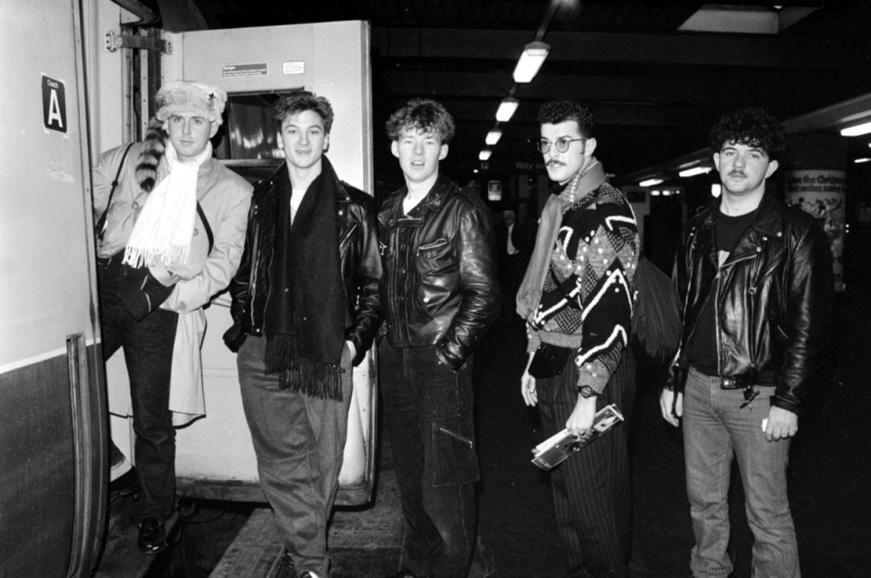 Lead singer of Frankie Goes to Hollywood, Holly Johnson (left) leads the group on to a train bound for Liverpool at Euston Station, 1984 (PA)