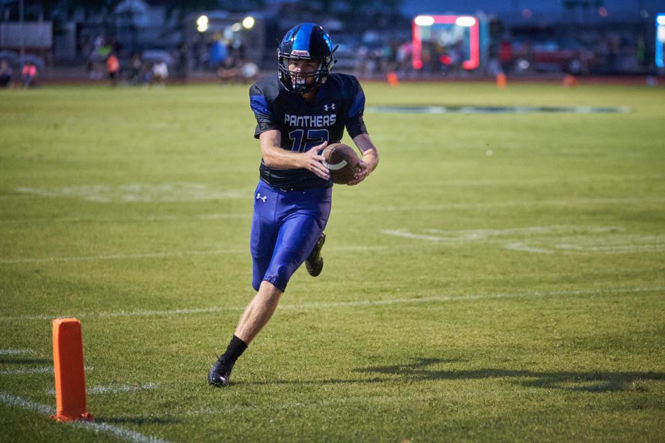 Paradise Honors junior quarterback Gage Baker (12) extends the ball into the end zone as he rushes it scoring a touchdown against Wickenburg at Paradise Honors High football field in Surprise on Aug. 19, 2022.