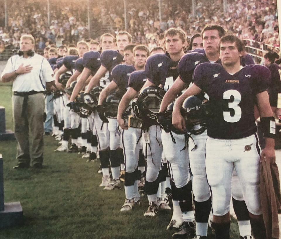 Head coach Scott Leitheiser stands at attention with members of Watertown High School's football team in 2009.
