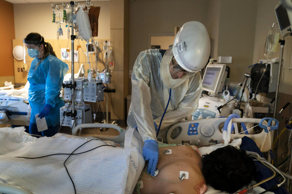 FILE - In this Nov. 19, 2020, file photo, Dr. Rafik Abdou checks on a COVID-19 patient at Providence Holy Cross Medical Center in the Mission Hills section of Los Angeles. U.S. hospital intensive care units in many parts of the country are straining under record numbers of COVID-19 patients. (AP Photo/Jae C. Hong, File)