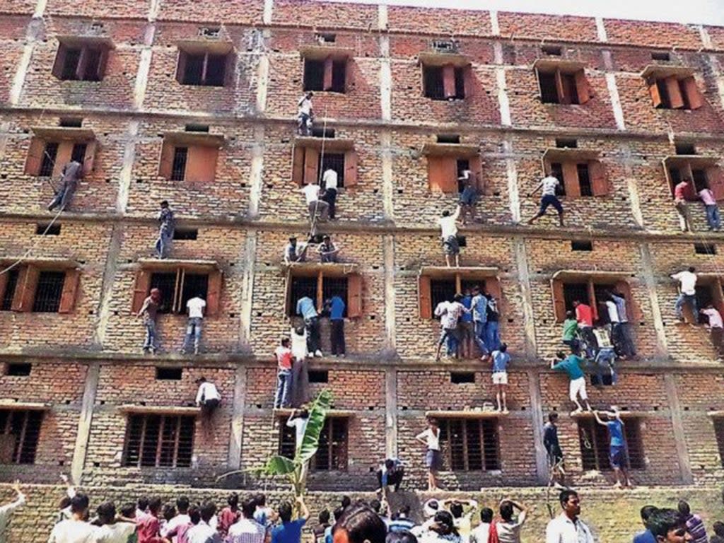 File: Stories of brazen exam cheating have gone viral in the past, as in this 2015 incident where accomplices scaled the outside of the exam hall building in Bihar  (AP)