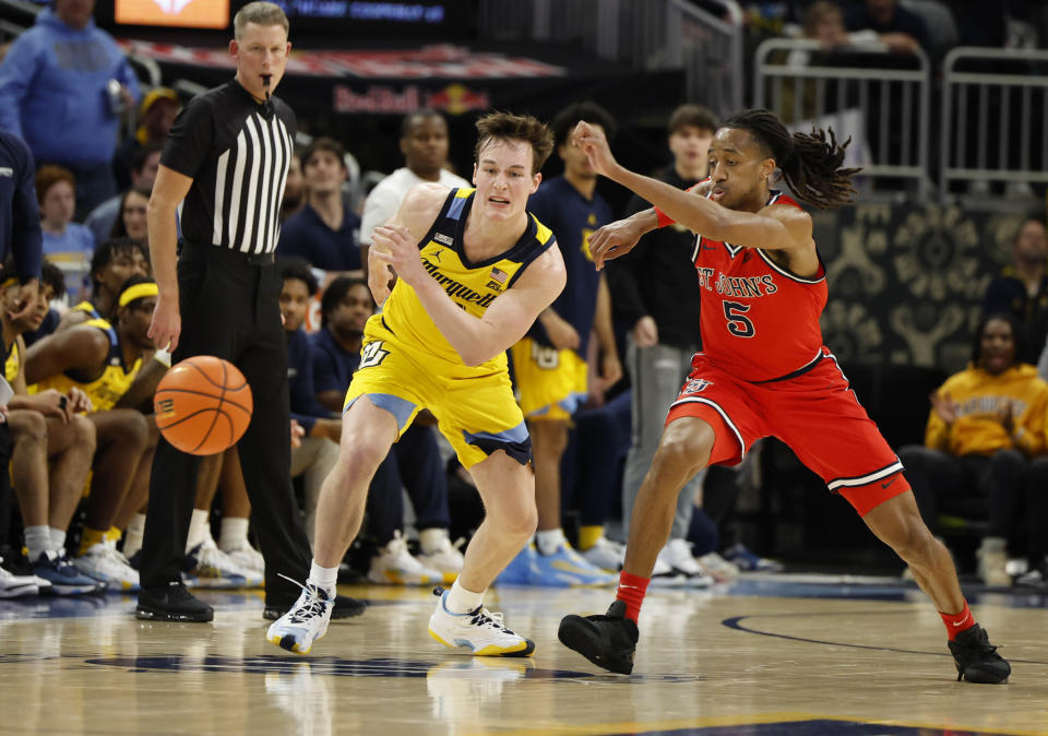 Marquette's Tyler Kolek (11) and St. John's RJ Luis Jr. 5) chase the ball during the second half of an NCAA college basketball game Saturday, Feb. 10, 2024, in Milwaukee. (AP Photo/Jeffrey Phelps)