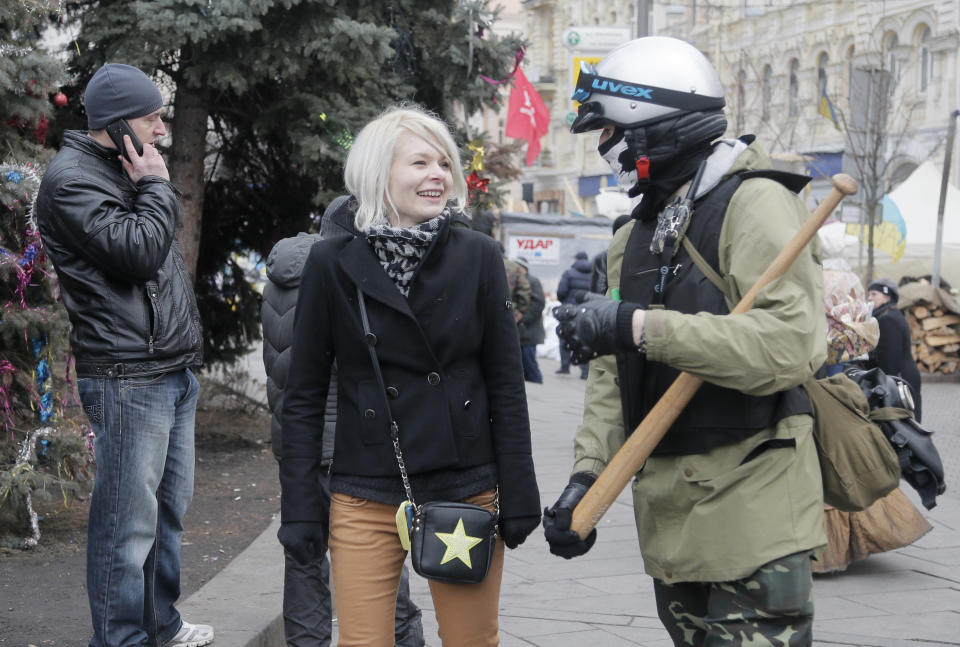 An opposition protester and his girlfriend walk in Kiev's Independence Square, the epicenter of the country's current unrest, Ukraine, Sunday, Feb. 16, 2014. Anti-government demonstrators in Ukraine's capital ended their nearly three-month occupation of Kiev City Hall on Sunday as promised in exchange for the release of all jailed protesters. But tensions remained high as hundreds stayed outside the building, vowing to retake it if the government fails to drop all criminal charges against the protesters. (AP Photo/Efrem Lukatsky)