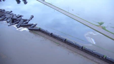 Tanker cars from a freight train carrying crude oil are shown after a derailment  along the Rock River south of Doon, Iowa, U.S. in this June 22, 2018 handout still image taken from aerial drone video.   Sioux County Sheriff's Office/Handout via REUTERS