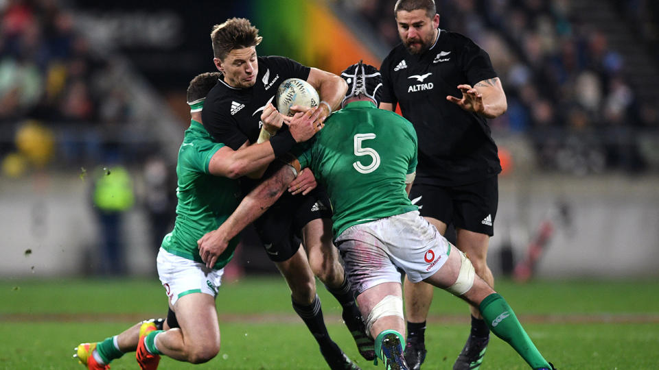 All Blacks player Beauden Barrett is tackled by two Ireland rivals.