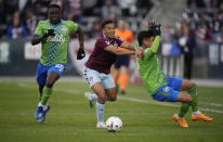 Colorado Rapids forward Jonathan Lewis, center, pursues the ball with Seattle Sounders defenders Yeimar Gómez, left, and Xavier Arreaga in the second half of an MLS soccer match, Sunday, May 22 2022, in Commerce City, Colo. (AP Photo/David Zalubowski)