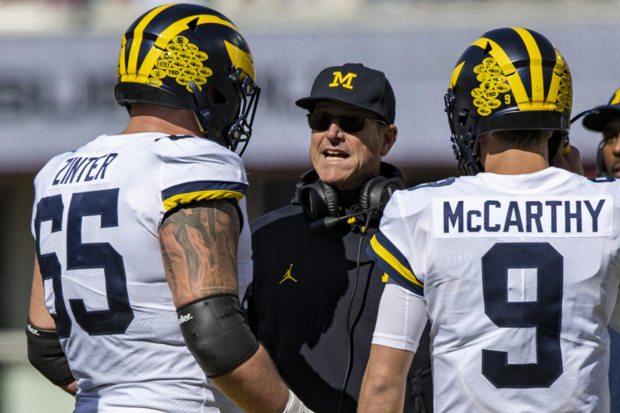 Michigan head coach Jim Harbaugh talks with offensive lineman Zak Zinter (65) and quarterback J.J. McCarthy (9) during an NCAA college football game, Saturday, Oct. 8, 2022, in Bloomington, Ind. (AP Photo/Doug McSchooler)