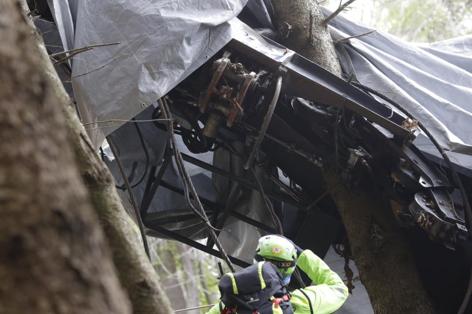A rescuer takes a picture of a clamp that was placed on an emergency brake, as search for evidence continues in the wreckage of a cable car after it collapsed near the summit of the Stresa-Mottarone line in the Piedmont region, northern Italy, Wednesday, May 26, 2021. Police have made three arrests in the cable car disaster that killed 14 people after an investigation showed a clamp, placed on the brake as a patchwork repair effort, prevented the brake from engaging after the lead cable snapped. (AP Photo/Luca Bruno)