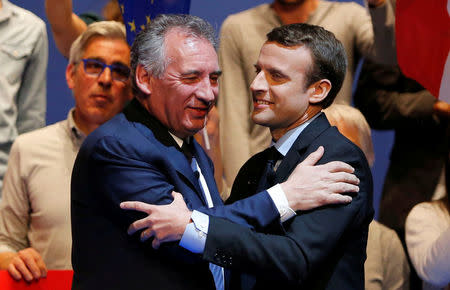 Emmanuel Macron (R), head of the political movement En Marche! (Onwards!) and candidate for the 2017 presidential election, and Francois Bayrou, French centrist politician and the leader of the Democratic Movement (MoDem), embrace as they attend a campaign rally in Pau, France, April 12, 2017. REUTERS/Regis Duvignau