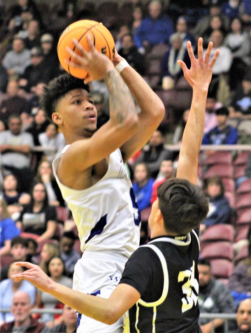 Xavier Davis of Pueblo Central rises up over his defender Mateo Esquivel of Pueblo South as he drains a shot in a the Colts 55-31 victory over the Wildcats at Southwest Motor Event Center on Jan. 31, 2023.