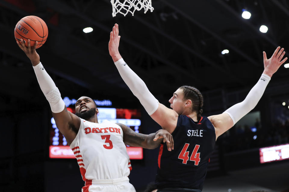 Dayton's Trey Landers (3) drives to the basket against Duquesne's Baylee Steele (44) in the first half of an NCAA college basketball game, Saturday, Feb. 22, 2020, in Dayton, Ohio. (AP Photo/Aaron Doster)
