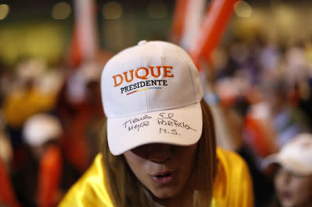 A woman sports a hat reading "Duque for president" and "You have the best political party," as supporters of Colombian right-wing presidential candidate Ivan Duque celebrate after he won a spot in a June runoff with leftist Gustavo Petro after Colombians voted for president in Sunday's first round presidential election, in Bogota, Colombia, May 27, 2018. REUTERS/Carlos Garcia Rawlins