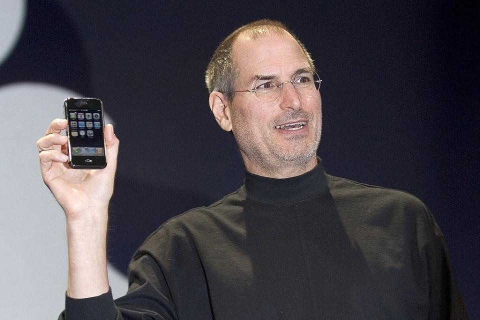 closeup of steve jobs holidng up the first iphone