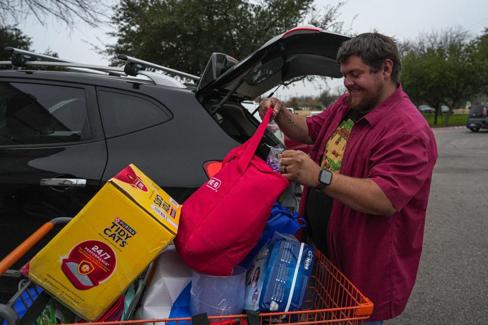 Hutto resident Michael Dahms loads his car after picking up food at the Round Rock Area Serving Center last month.