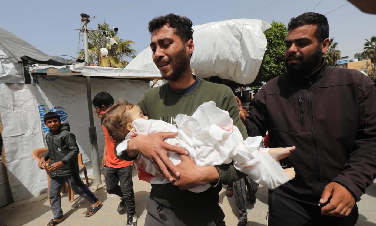 <span>Relatives of a Yasmeen Abu Rkab, aged two, who died in Israeli attacks, receive her body from the morgue of Al-Aqsa hospital in Gaza on Wednesday.</span><span>Photograph: APAImages/Rex/Shutterstock</span>