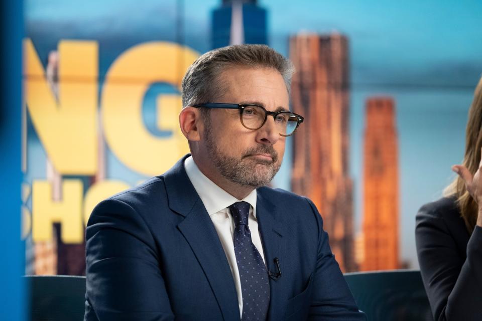 Steve Carell sits behind a news desk