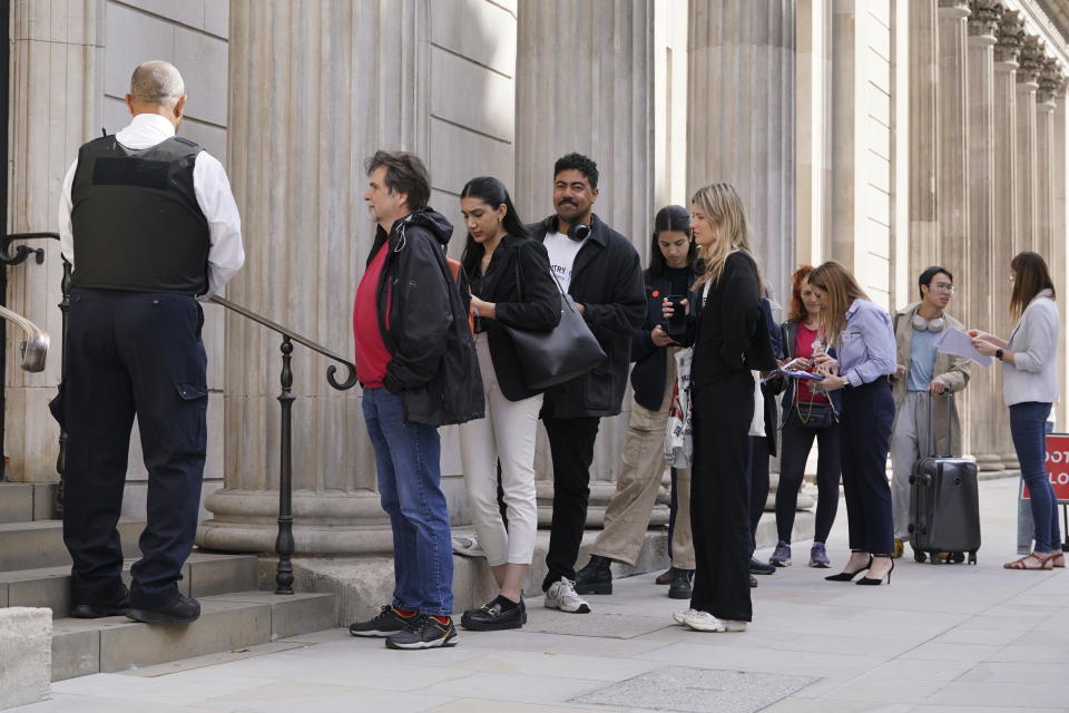 People queue outside the Bank of England on the day the new banknotes featuring the King's portrait are being issued, in London, Wednesday June 5, 2024. (Lucy North/PA via AP)