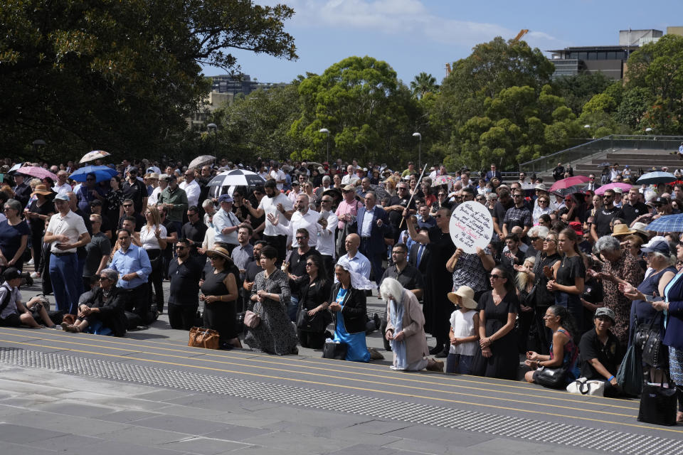 Some mourners kneel as the pray outside St. Mary's Cathedral during the funeral and interment of polarizing Cardinal George Pell in Sydney, Thursday, Feb. 2, 2023. Pell, who died last month at age 81, spent more than a year in prison before his sex abuse convictions were overturned in 2020. (AP Photo/Rick Rycroft)