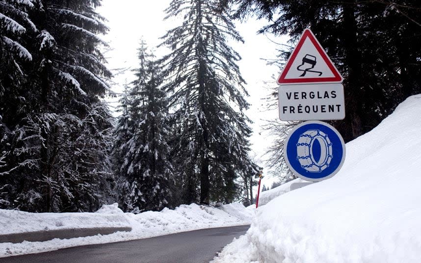 A sign in France warning of black ice and telling drivers to fit snow chains - Credit: Rebecca Coles / Alamy Stock Photo