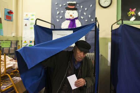 A man exits a voting booth to cast his ballot at a polling station in an elementary school during Greece's parliamentary elections in Athens January 25, 2015. REUTERS/Marko Djurica