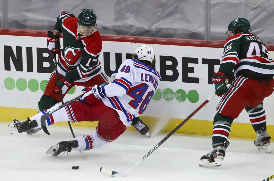 New Jersey Devils center Yegor Sharangovich (17), defenseman Sami Vatanen (45) and New York Rangers left wing Brendan Lemieux (48) battle for the puck during the third period of an NHL hockey game in Newark N.J., on Saturday, March 6, 2021. (Andrew Mills/NJ Advance Media via AP)