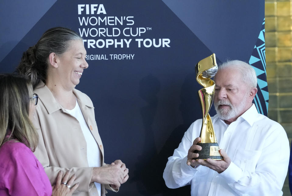 Brazil's President Luiz Inacio Lula da Silva holds the FIFA Women's World Cup Trophy as Minister of Sports Ana Moser looks on during the trophy's tour ahead of the Australia - New Zealand 2023 World Cup soccer tournament at Planalto palace in Brasilia, Brazil, Thursday, March 30, 2023. (AP Photo/Eraldo Peres)