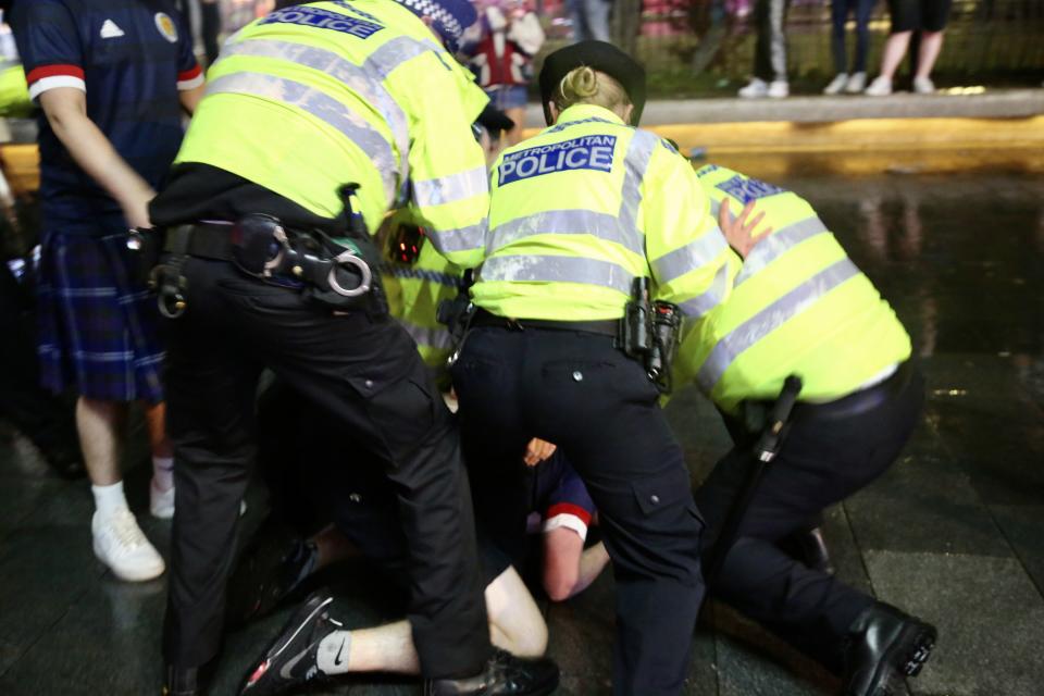 Police officers take a fan into custody at Leicester Square after Scotland played to a goalless draw against rivals England (Anadolu Agency/Getty Images)