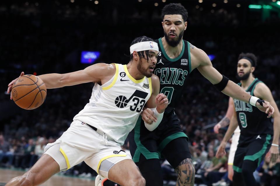 Utah Jazz's Johnny Juzang (33) drives against Boston Celtics' Jayson Tatum (0) during the first half of an NBA basketball game Friday, March 31, 2023, in Boston. (AP Photo/Michael Dwyer)