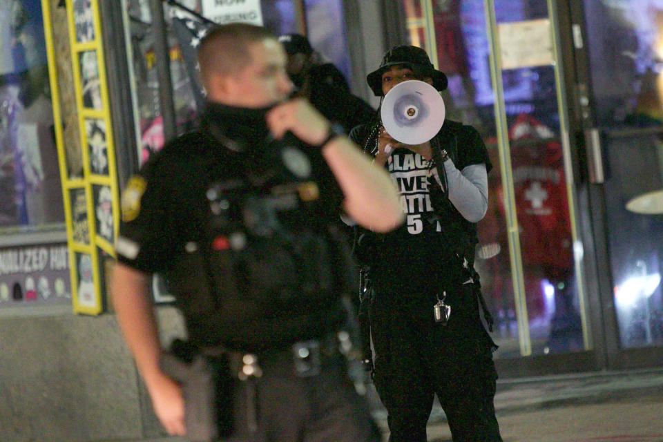 Police officers redirect traffic along Atlantic Avenue while Japharii Jones with Black Lives Matter 757 protests through a loud speaker demanding justice for Donovan Lynch in Virginia Beach, Va., on Saturday, March 27, 2021. (Karen Zeis/The Virginian-Pilot via AP)