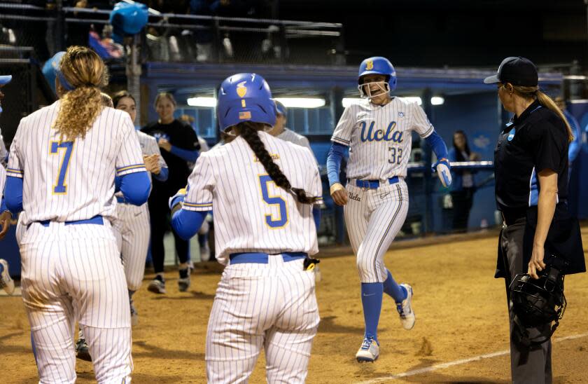 WESTWOOD, CA - MAY 23, 2024: UCLA pinch runner Gabriela Jaquez (32) scores after UCLA infielder Jordan Woolery (15) hit a 3-run homer against Georgia in the fifth inning during the NCAA Division I Softball Los Angeles Super Regional at Easton Stadium on the UCLA campus on May 23, 2024 in Westwood, California.UCLA Maya Brady (7) and UCLA Savannah Pola (5) greet her a home plate.(Gina Ferazzi / Los Angeles Times)