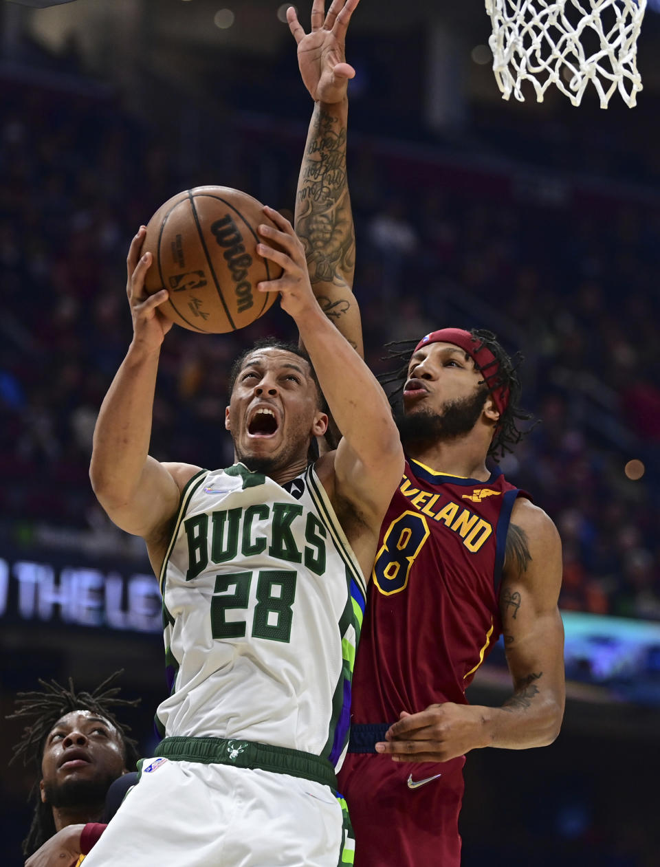 Milwaukee Bucks guard Lindell Wigginton goes to the basket against Cleveland Cavaliers forward Lamar Stevens in the first half of an NBA basketball game, Sunday, April 10, 2022, in Cleveland. (AP Photo/David Dermer)