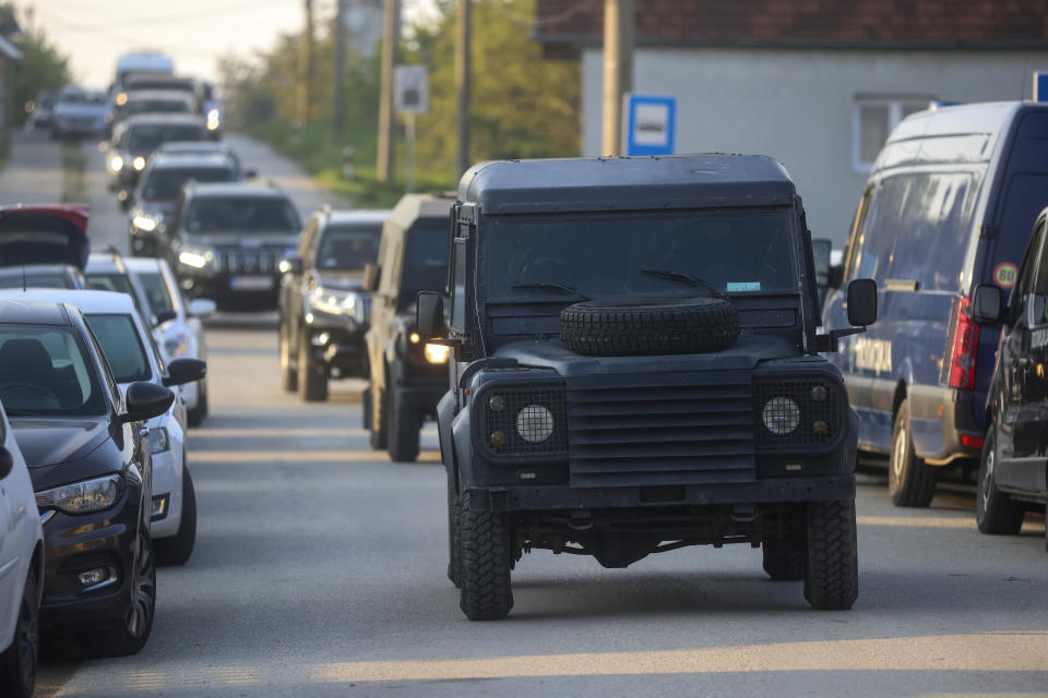 Convoy of police cars arrive at the scene of a Thursday night attack in the village of Dubona, some 50 kilometers (30 miles) south of Belgrade, Serbia, Friday, May 5, 2023. A shooter killed multiple people and wounded more in a drive-by attack late Thursday in Serbia's second such mass killing in two days, state television reported.(AP Photo/Armin Durgut)