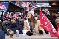 People watch a rally for President Donald Trump on a large screen television from a bar near the rally site in Wildwood, N.J., Tuesday, Jan. 28, 2020. (AP Photo/Seth Wenig)