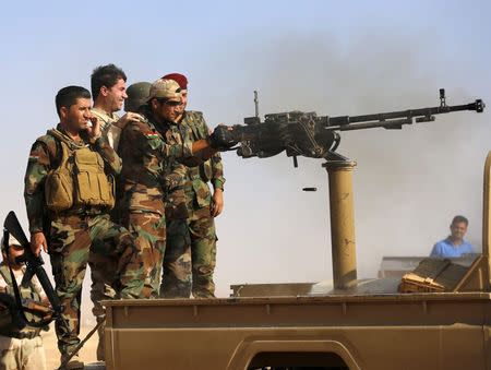 Kurdish Peshmerga fighters fire in the direction of Zummar, controlled by Islamic State (IS) near Mosul September 15, 2014. REUTERS/Ahmed Jadallah