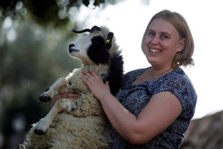 Shepherdess Jenna Lewinsky holds a lamb from the Jacob sheep breed, in Ramot Naftali, Israel, February 21, 2018. Picture taken February 21, 2018. REUTERS/Amir Cohen