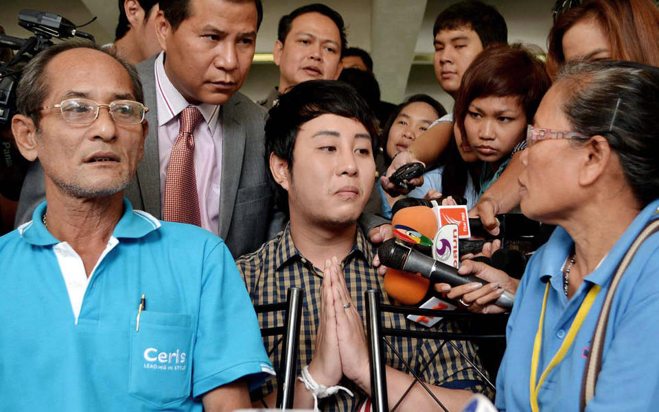 In this photo taken Sept. 21, 2012, Thanatch Natveerakul, center, an unlicensed practitioner who injected a botched collagen to aspiring model Atitaya Iamyai is surrounded by reporters as he offers an apology to Lamiad Iamyai, left, and Rabiab Pinklub, right, parents of Atitaya at a hospital in Bangkok, Thailand. Atitaya later died after more than a week in the hospital and her death has drawn attention to the dark side of a booming beauty industry in Thailand. Thanatch who was charged on unintentional murder has been released on bail. (AP Photo/The Daily News) EDITORIAL USE ONLY