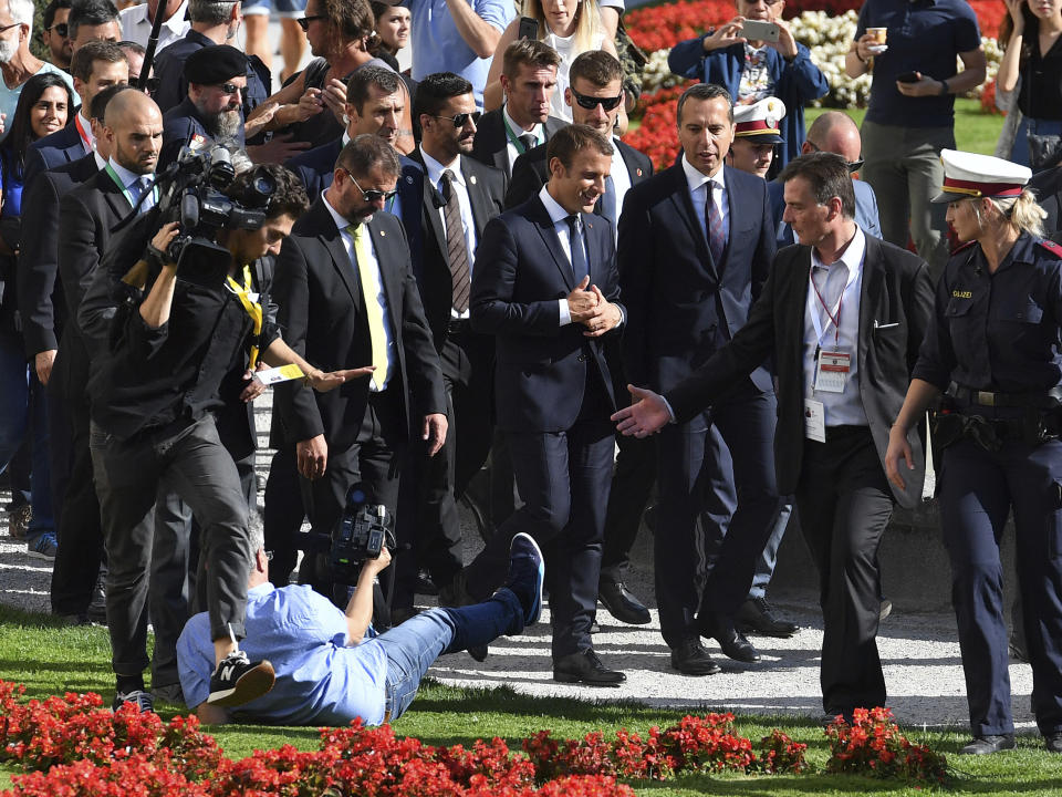 <p>Beim Besuch des französischen Präsidenten Emmanuel Macron in Salzburg drängeln sich die Fotografen so sehr, dass einer von ihnen direkt neben dem hochrangigen Besuch zu Fall kommt. Österreichs Kanzler Christian Kern verfolgt den Sturz des Fotografen unbeeindruckt. (AP Photo/Kerstin Joensson) </p>