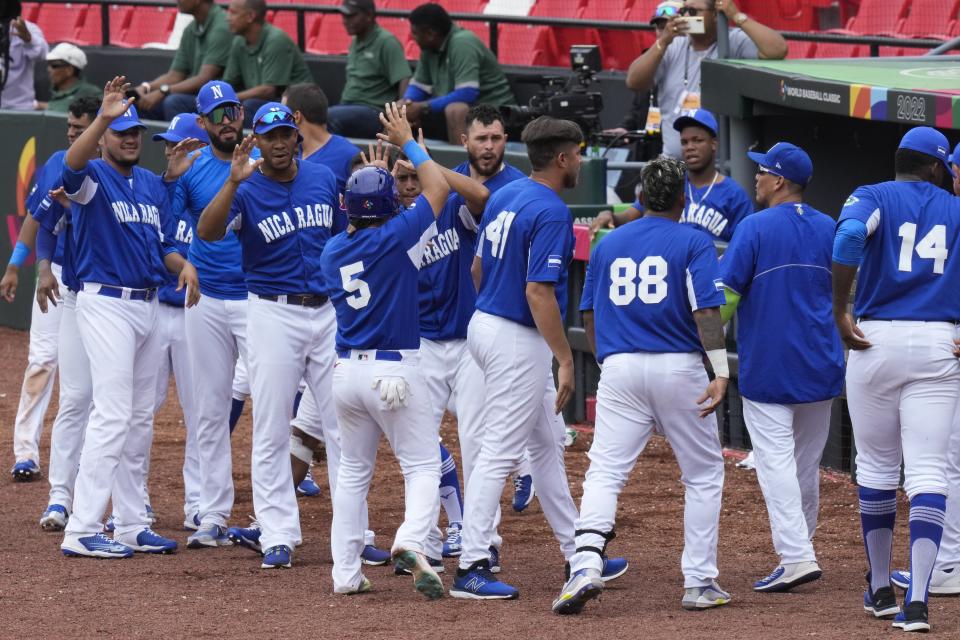 Brandon Steven Leyton (5) de Nicaragua es saludado por sus compañeros de equipo luego de anotar una carrera durante la séptima entrada de un juego clasificatorio para el Clásico Mundial de Béisbol contra Argentina en el Estadio Nacional Rod Carew en la Ciudad de Panamá, el martes 4 de octubre de 2022. Nicaragua ganó 6-5. (Foto AP/Arnulfo Franco)