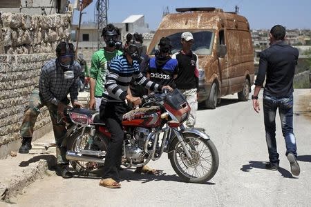 Civilians react as they wear gas masks after what activists said was a chlorine gas attack on Kansafra village at Idlib countryside, Syria May 7, 2015. REUTERS/Abed Kontar